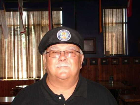 A man wearing glasses and a black hat.