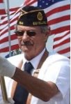 A man in uniform with an american flag behind him.