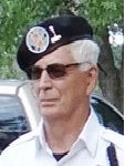 A man in sunglasses and a hat is standing outside.